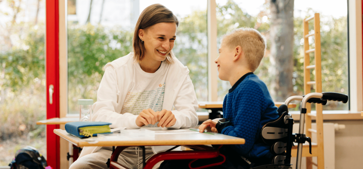 Nadja und Tommy sitzen an einem Tisch in der Schule. Sie arbeiten gemeinsam an einem Thema.