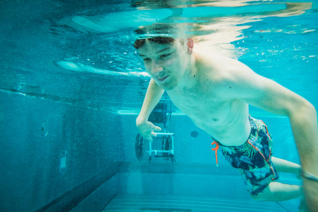 Junge taucht im Schwimmbecken
