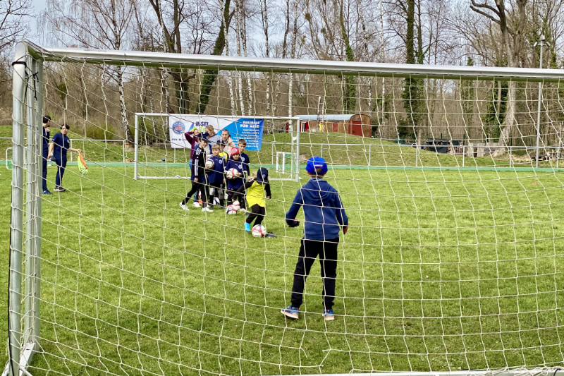 Kinder bei Torschusstraining auf Rasen