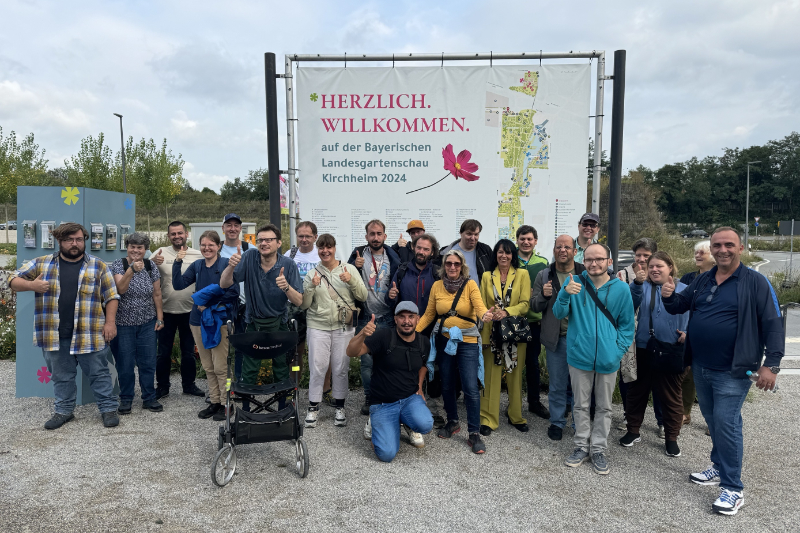 Viele Menschen nebeneinander Text: Herzlich Willkommen auf der Bayerischen Landesgartenschau Kirchheim 2024