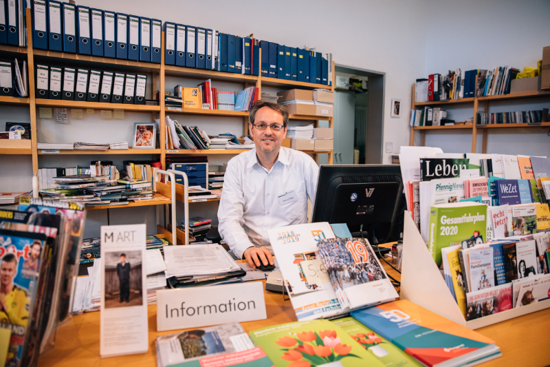 Mann hinter Büchertheke in Bibliothek