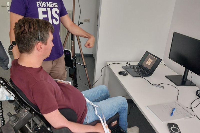 Forscher macht eine Handbewegung vor, die am Laptop dargestellt wird.