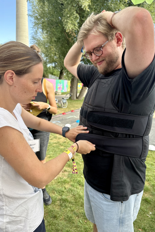 Frau legt Mann einen Brustgurt an