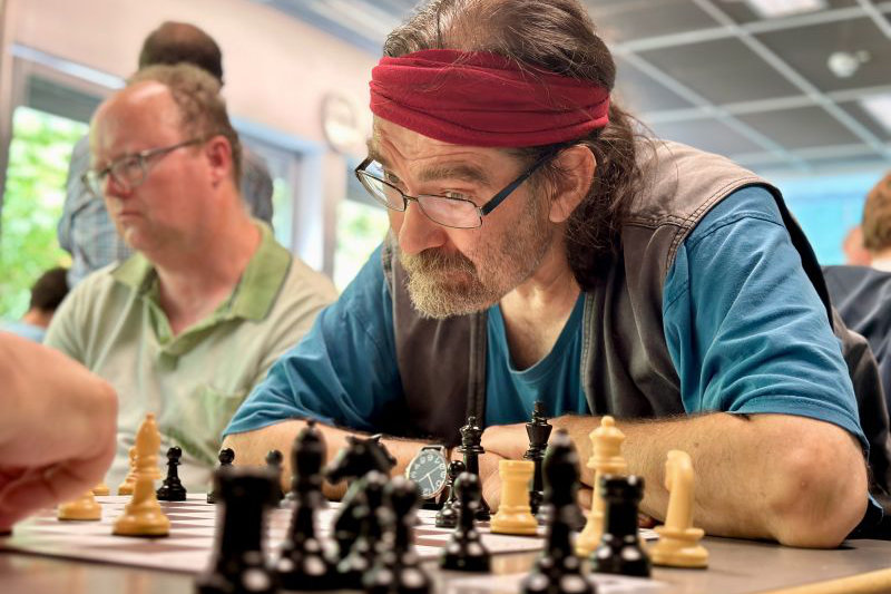 Mehrere Personen beim Schachspielen in einem Raum
