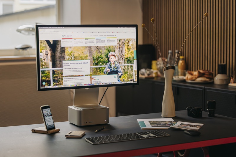 Computermonitor und Handydisplay auf Schreibtisch