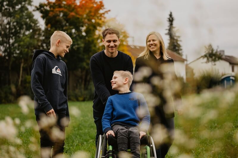 Familie mit Zwillingsbrüdern, einer davon im Rollstuhl