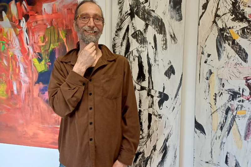 Mann steht in einem Raum vor einem Kunstwerk