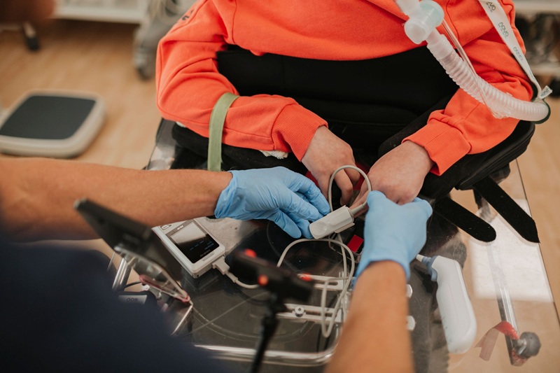 Person führ eine Messung der Vitalzeichen bei einer zweiten Person durch - Medizinische Versorgung von Menschen mit Behinderung in München