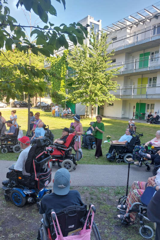 Mehrere Personen mit und ohne Rollstuhl im Innenhof des Forums