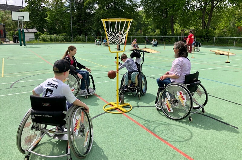 Mehrere Personen spielen Rollstuhlbasketball
