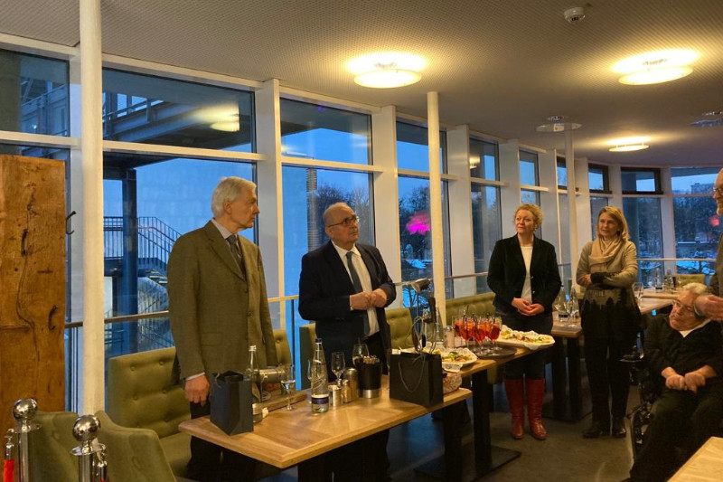Mitglieder des Stiftungsrates stehen um einen festlich gedeckten Tisch herum