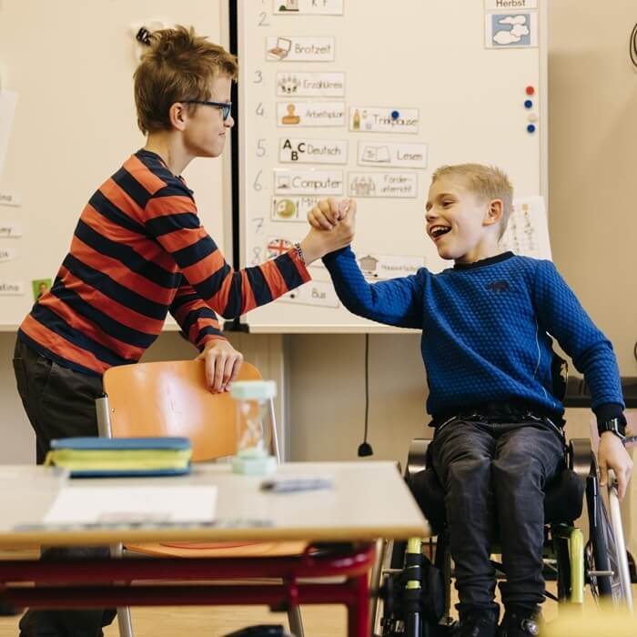 Zwei Kinder halten sich an der Hand