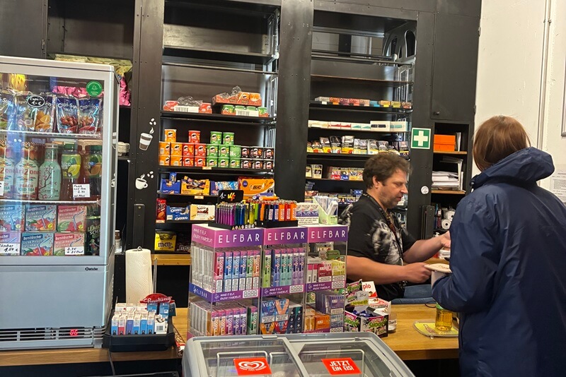 Kunde im Kiosk wird von einer Person bedient